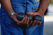 Mann mit Boule Kugeln in den Händen, Arles, Bouches-du-Rhone, Provence, Frankreich, Europa