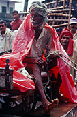 Coachman, plastic tarpaulin, monsoon, near Muzaffarpur, Bihar, India