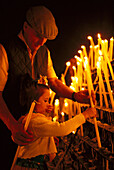 Pilgrims lighting a candle, El Rocío, Andalusia, Spain