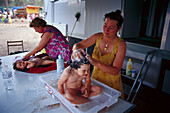 Frauen auf Pilgerfahrt waschen ihre Kinder in einem Feldlager, Andalusien, Spanien