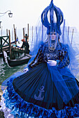 Verkleidete Person mit Maske am Wasser, Venedig, Venetien, Italien, Europa