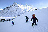 Three small children on a ski slope, skiing lesson, Gorfenspitze in the background, Wirl near Galtuer, Tyrol, Austria