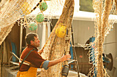 Fishermen in harbour, working on their net cala figuera, south, Mallorca, balearic islands, spain