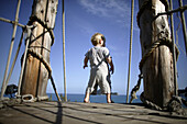 Kleine Junge steht auf eine Holzbrücke, Hotel Gloria Maris, Porto Koukla, Zakynthos Insel, Ionische Inseln, Griechenland