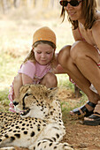 Girl stroking cheetah, Uitenhage, Eastern Cape, South Africa