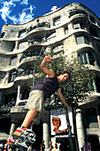 Junger Mann auf einem Skateboard vor dem Casa Mila, Barcelona, Spanien, Europa