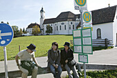 Japanische Touristen an der Bushaltestelle in der Nähe von Wieskirche, Steingaden, Bayern, Deutschland