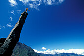 Climber standing on the top of a mountain peak, View to Piton de la Fournaise and Formica Leo, Trois Salazie, Ille de la Réunion, Indian Ocean