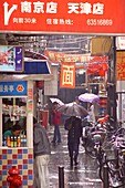 People in the city in the rain, Shanghai, China, Asia