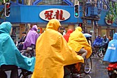 Cyclists in coulorful rain capes, Shanghai, China, Asia
