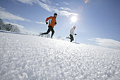 Young couple running through deep snow