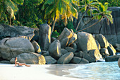 Frau entspannt sich am Strand, Anse Takamaka, Mahe, Seychellen