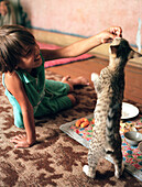 Girl feeding a cat, Uzbekistan