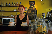 Ene junge Kellnerin serviert zwei große Cappuccinos, Innenaufnahme, Café, Neuseeland