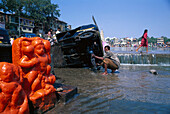 Mann wäscht sein Auto am heiligen Badegath im Fluss Godavari, Nasik, Maharashtra, Indien, Asien