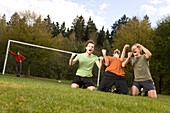 Young male soccer players jubilating, on their knees