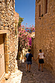Couple walking down an alley in the medieval village of Monemvasia, Lakonia, Peloponnese, Greece