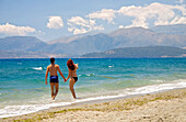 Couple walking along the beach, hand in hand, Beach near Gythio, Peloponnese, Greece