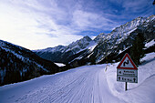 Verschneite Strasse und Verkehrsschild in den Bergen, Staller Sattel, Antholz, Pustertal, Südtirol, Italien, Europa