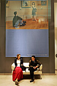 Couple talking on couch, Louvre, Paris, France