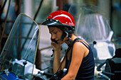 Junge Frau mit Handy auf Motorroller, Rom, Latium, Italien, Europa
