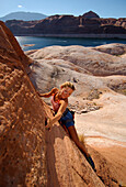 Woman climbing at Lake Powell, Arizona, USA