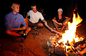 Drei Leute sitzen am Lagerfeuer, Camping, Zelten, Arizona, USA