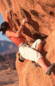 Woman bouldering, Tafraout, Morocco, Africa