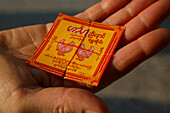 Close-up, gold leaf package, Golden Rock, Paeckchen, Blattgold, Nahaufnahme, Applying gold leaf for meritorious deeds, pilgrims at Kyaikhtiyo, Goldblaettchen