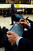 Businessman with electronic organizer at station