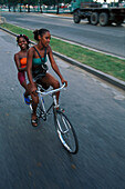 Two young women riding a bike, Cuba, Greater Antilles, Antilles, Carribean, Central America, North America, America