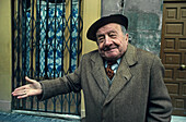 Lächelnder alter Mann vor Hauseingang, Frankreich