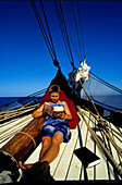 Sailor girl, Read, Traditional Sailing Ship-Open Ocean French Polynesia, South Pacific