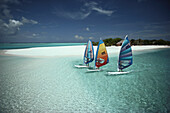 Drei Windsurfer vor dem Strand des Reti Raa Resort, Malediven, Indischer Ozean