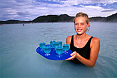 Junge Frau serviert Getränke in Warmwassersee, Blue Lagoon, Grindavik, Island