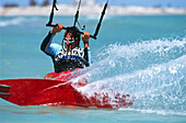 Man kiteboarding at great speed, gripping line with two hands