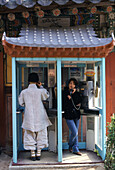 Monk and woman, telephone booth in Haein-sa monast, Haein-sa, Kayasan National Park South Korea, Asia