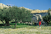 Man with bike in flower meadow, Sicily Italy