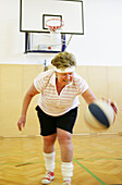 Mature Woman playing basketball