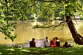 Junge Leute unter einem Baum im Park, Leipzig, Sachsen, Deutschland, Europa