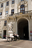 Fiaker passing Alte Hofburg during a city tour, Vienna, Austria