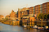 Blick auf eine Reihe von Backsteingebäuden der Speicherstadt im Sonnenlicht, Hamburg, Deutschland