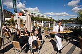 Waiter serving food in the Alsterpavillon, Waiter serving food in open-air area of the restaurant Alsterpavillon, Hamburg, Germany