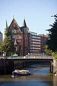 Barge passing brick-lined buildings of Speicherstadt, Hamburg, Germany