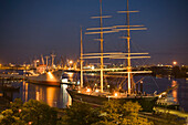 St. Pauli Landungsbrücken and cranes, View over tower at Landungsbrücken to dockyard with cranes at night, Sankt Pauli, Hamburg, Germany
