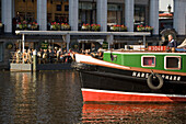 Excursion with a barge, Barge on a loading canal during a excursion passing a cafe at Alsterarkaden, Hamburg, Germany