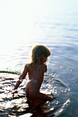 Little girl playing in lake