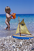 Little girl playing on beach, Karpathos, Dodecanese Islands, Greece