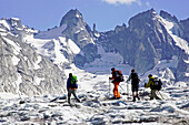 Four people hiking on a glacier, Forno Glacier, Bregaglia, Bergell, Graubuenden, Grisons, Switzerland