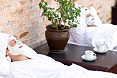 Couple having face mask in spa